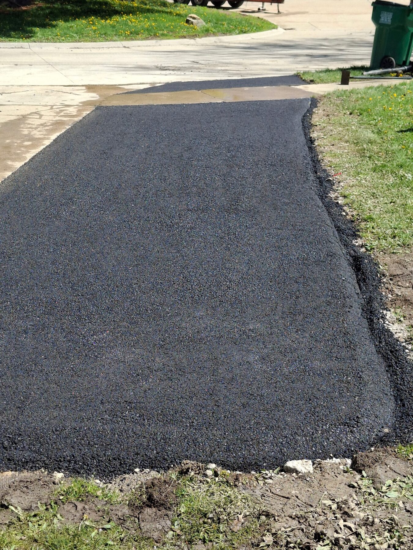 Fresh asphalt driveway apron installation