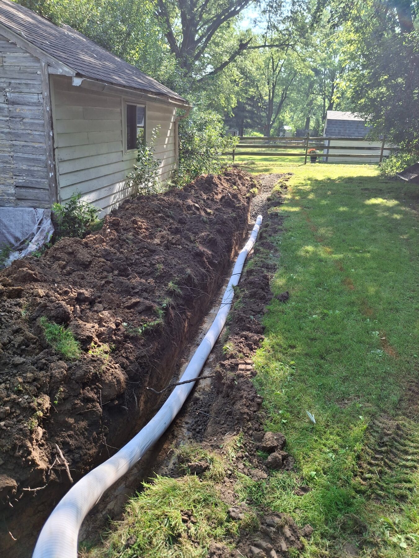 French drain trench excavation beside a structure